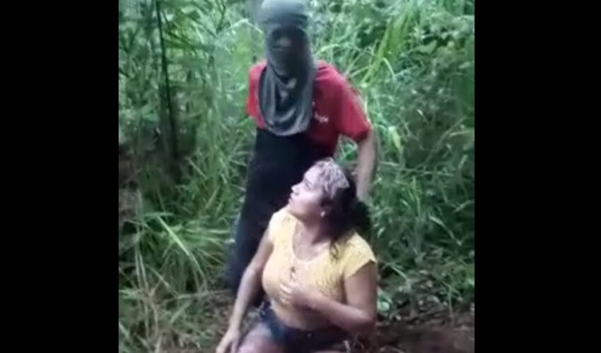 Woman being beheaded while receiving machete blows and stabs in the belly.