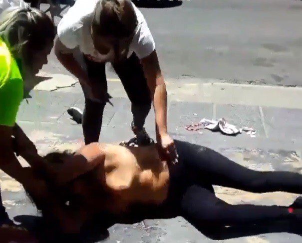 Woman being beaten, humiliated and stripped in the middle of the street.