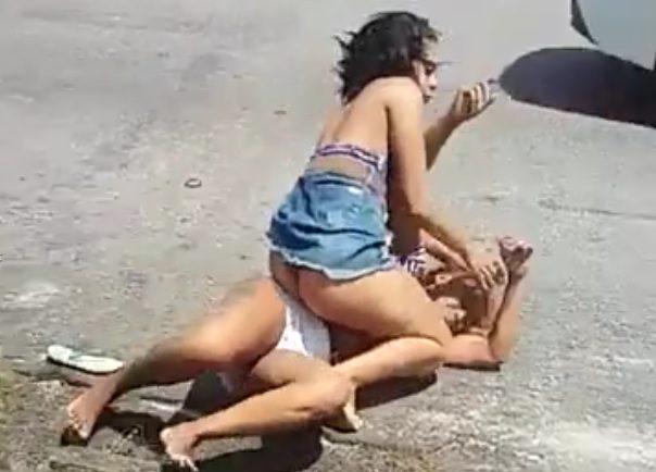 Hot woman fight in the middle of the street in front of the bar.