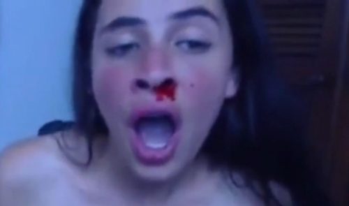 Woman punches her own face until her nose bleeds.