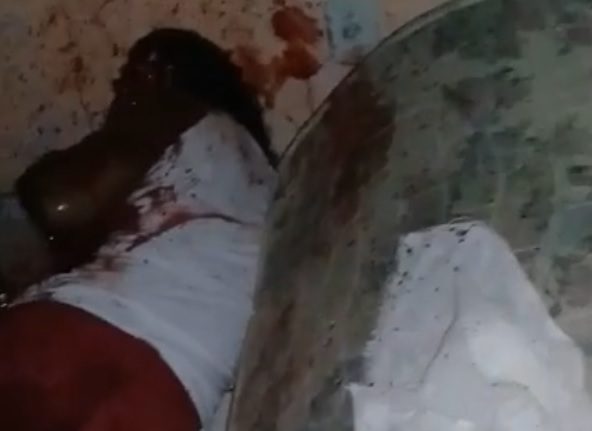 Woman being killed by machete blows inside the room without reacting to death.