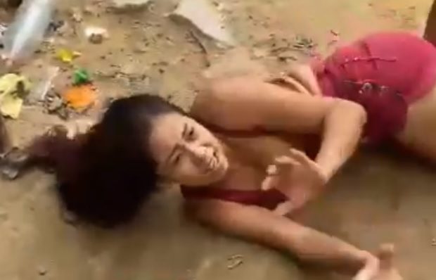 Woman being punished for allegedly hitting a child in the favela in Brazil.