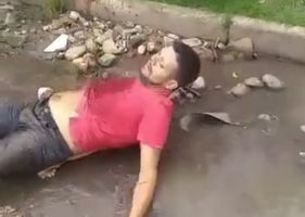 Alleged thief is shot in the back and agonized by pain in the sewer water.