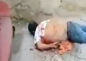 Man is executed with machine gun fire by cartel members until his guts protrude from his belly.