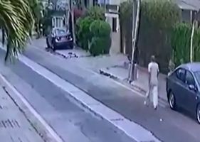 Old man is attacked by two ferocious dogs as he walks down the street.