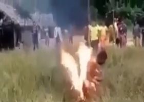 Man being burned alive in the bush for no apparent reason.