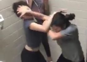 Several girls fighting in the ladies room in an all-out brawl.