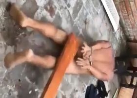 Alleged thief being beaten completely without clothes as punishment for his actions.