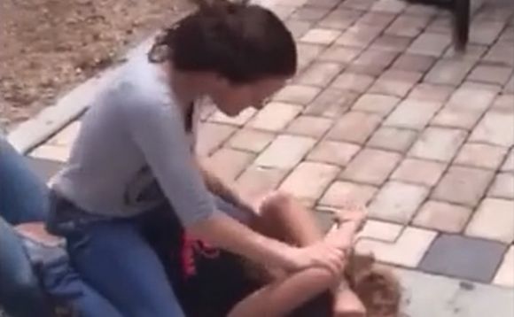 Fight between two girls in the schoolyard ends with one girl hitting the other's head repeatedly on the concrete Photo 0001 Video Thumb