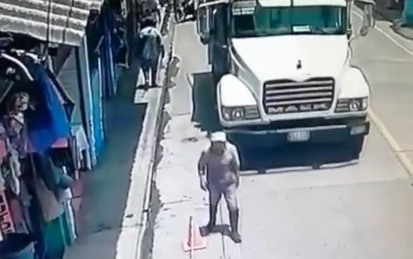 Worker is run over by truck and his head explodes crushed throwing his brain to the sidewalk.