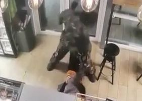 Female store clerk is brutally attacked and punched in the face by a man dressed as a soldier in Russia.