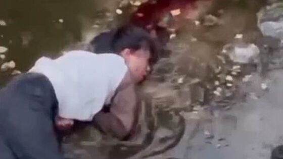 A man fleeing the police in china shoots himself and ends up convulsing on the ground on the verge of death in a sewage stream Photo 0001 Video Thumb